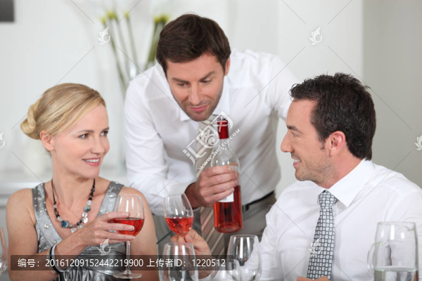 男子在晚宴上供應玫瑰酒