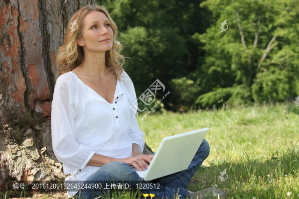 金發(fā)女人坐在樹(shù)上，筆記本電腦在思考