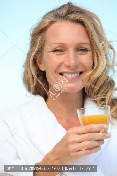 一個穿著長袍和喝橙汁的女人。