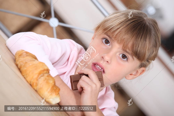 年輕的女孩和一個牛角包和巧克力