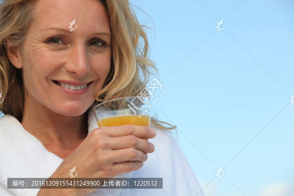 金發(fā)女人戶外喝橙汁