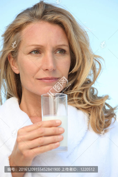 穿著睡衣的女人手里拿著一杯牛奶