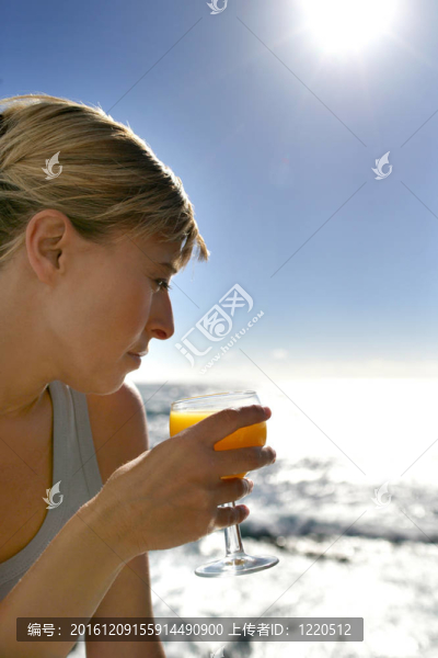 在海灘上喝提神飲料的婦女
