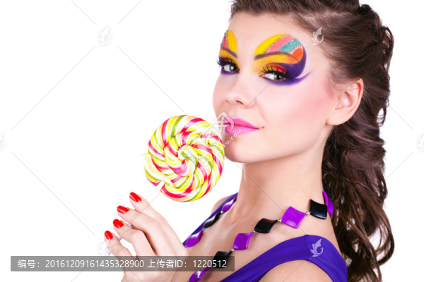 一個(gè)有魅力的美麗的女人拿著棒棒糖的肖像
