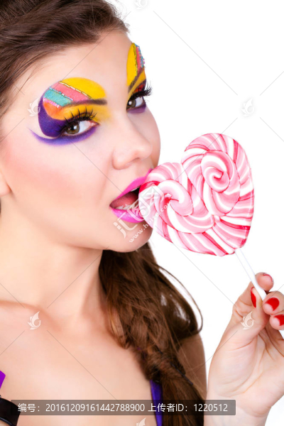 一個(gè)有魅力的美麗的女人拿著棒棒糖的肖像