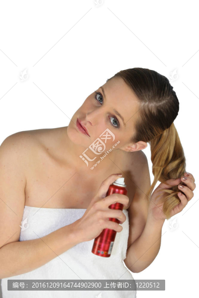 裸肩的金發(fā)女郎裹著毛巾照顧她的頭發(fā)