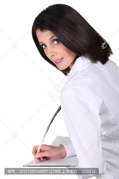 用羽毛寫(xiě)在筆記本上的女人