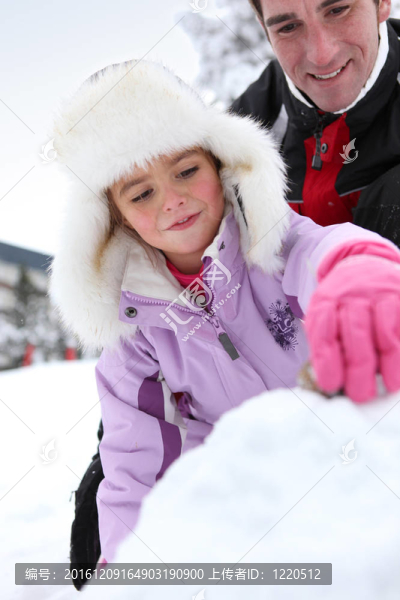 父親和女兒在雪地里玩