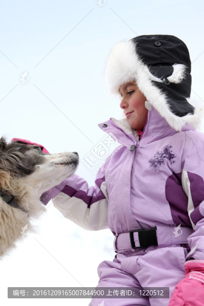 小女孩撫摸著狗在滑雪