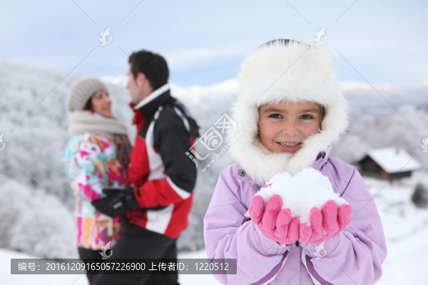 小女孩和父母一起在雪地里玩