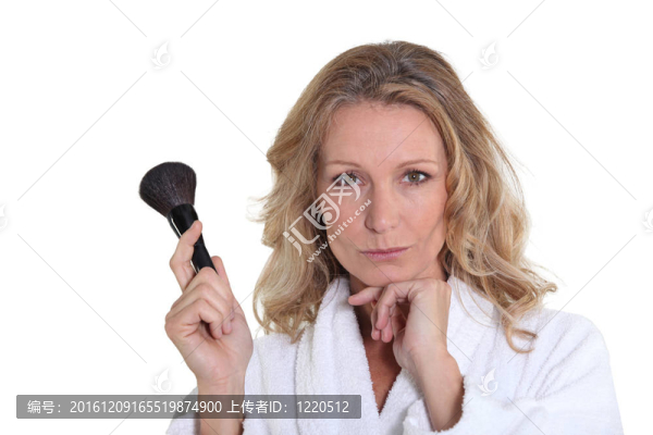 在浴衣拿化妝刷的金發(fā)女人