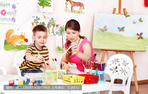 兒童與老師畫涂料在游戲室。