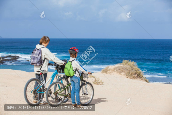 在海灘上騎自行車的女孩和奶奶