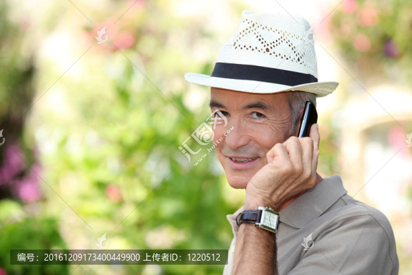 65歲的老男人，戴著草帽和打電話