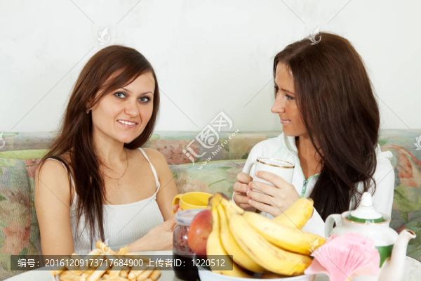 兩個微笑的女人喝茶