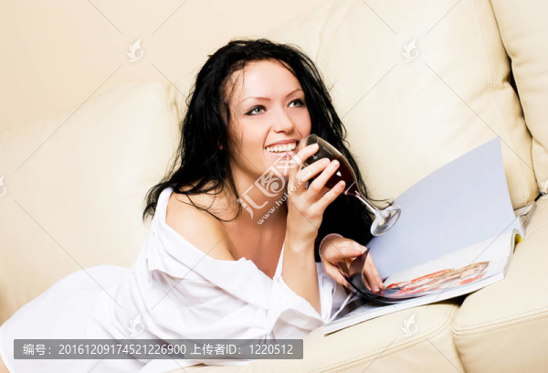美麗的女人在沙發(fā)上放松與雜志