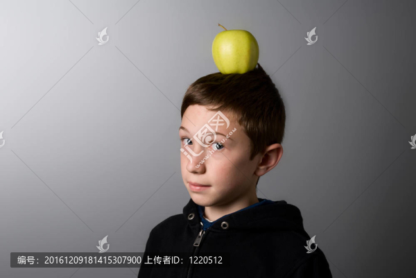 頭上有一個綠蘋果的男孩