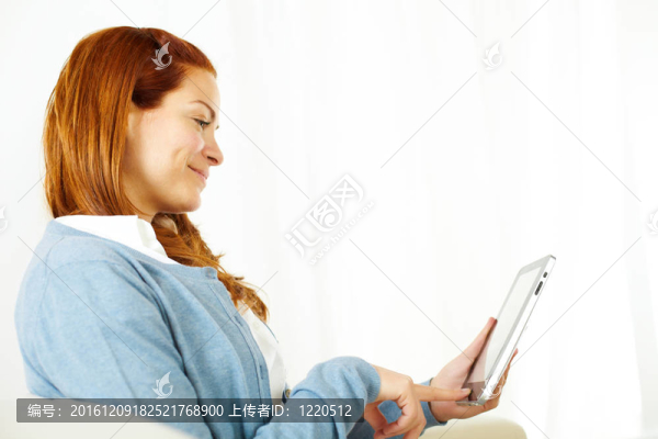 安靜的年輕女性在平板電腦上工作