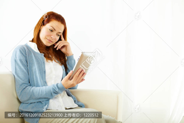 可愛的年輕女性在平板電腦上工作