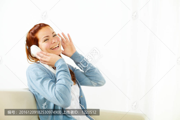 快樂(lè)的年輕女人在聽(tīng)音樂(lè)