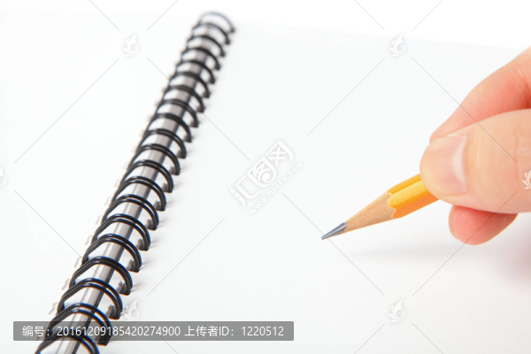 手拿鉛筆寫在筆記本上