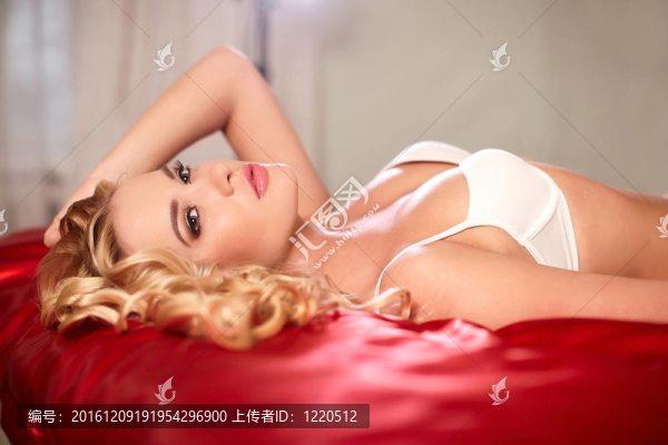 美麗的性感女孩躺在床上的白色內(nèi)衣與明亮的化妝和發(fā)型