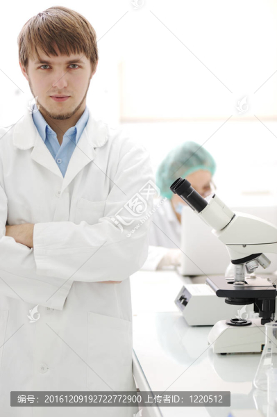 兩個科學家在實驗室用顯微鏡工作