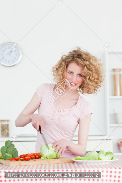 漂亮的金發(fā)女人在廚房里煮蔬菜