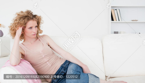 迷人的金發(fā)女子放松，而坐在沙發(fā)上