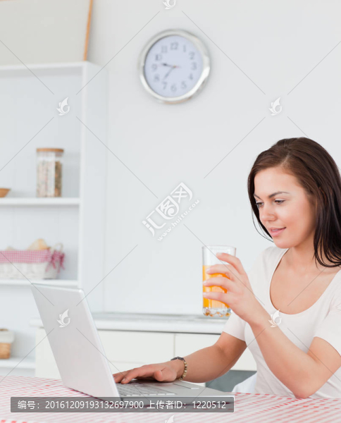 一個女人使用筆記本電腦和喝果汁的肖像