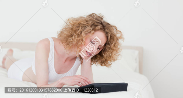 漂亮的金發(fā)女人放松她的碑躺在她的公寓床
