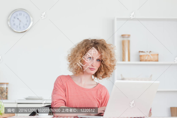 漂亮的金發(fā)女人坐著用筆記本電腦放松