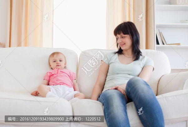 坐在沙發(fā)上的漂亮女人看著她的寶貝