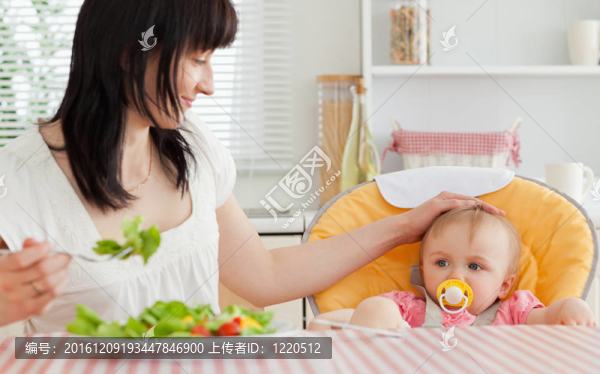 漂亮的黑發(fā)女人吃沙拉在她的寶貝