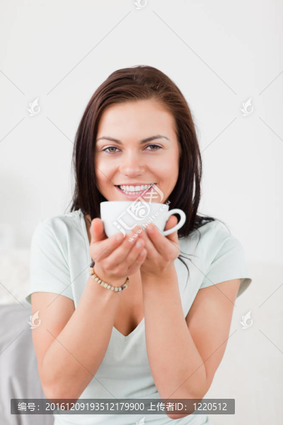 一個(gè)面帶微笑的黑發(fā)女人喝茶的肖像