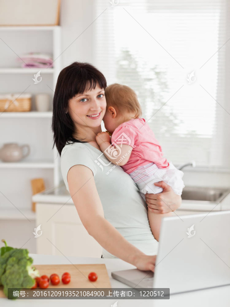 漂亮的黑發(fā)女人抱著她的孩子在她的懷里