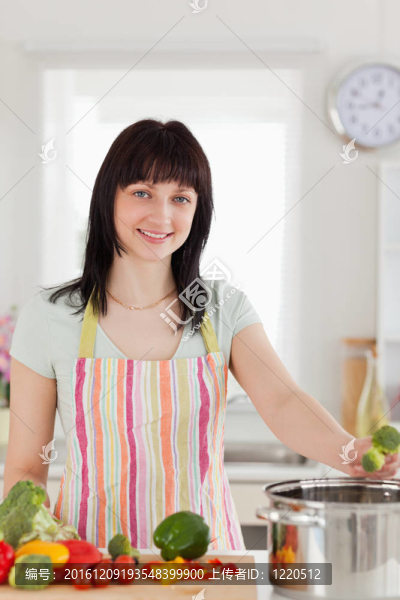 漂亮的黑發(fā)女子冒充烹調(diào)蔬菜時