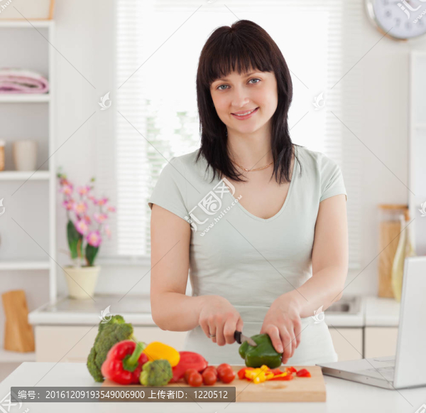 漂亮的黑發(fā)女人做飯而放松她的筆記本電腦