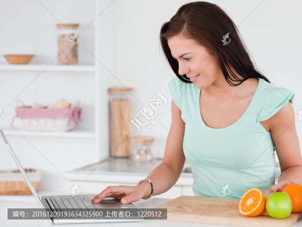 帶筆記本電腦和水果的年輕女人