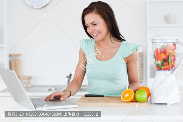 年輕的黑發(fā)與筆記本電腦和水果