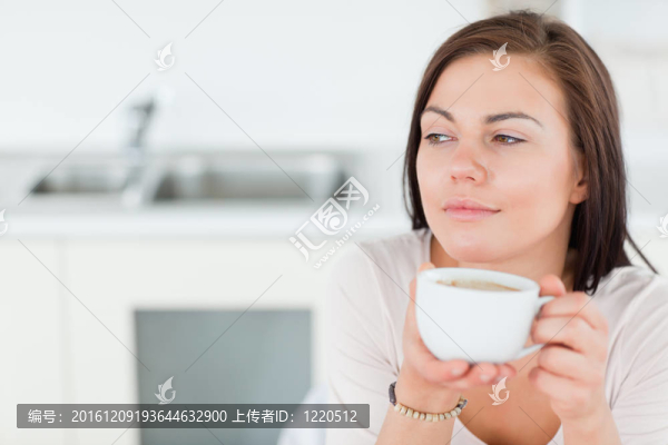 一個(gè)面帶微笑的黑發(fā)女人喝著咖啡