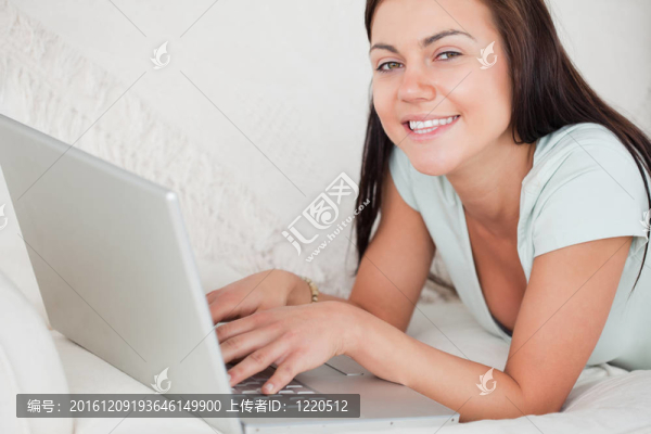 沙發(fā)上微笑的女人用筆記本特寫