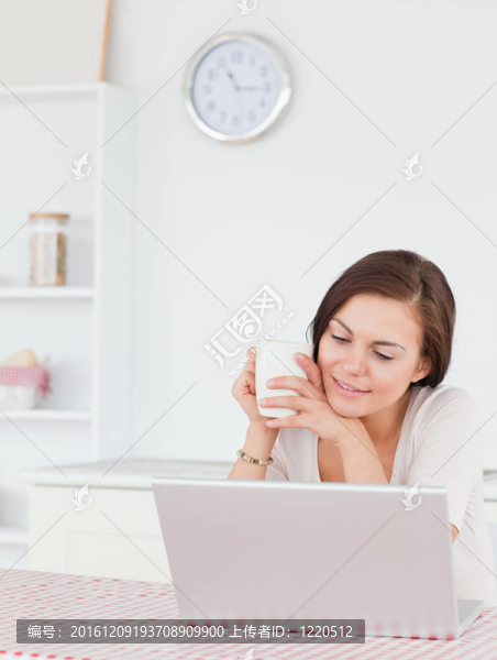 一個(gè)女人用筆記本電腦喝茶