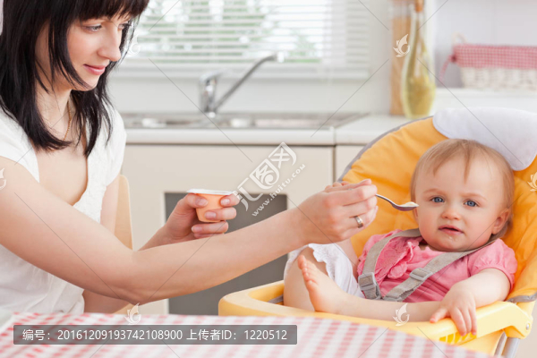 漂亮的黑發(fā)女人坐在喂寶寶
