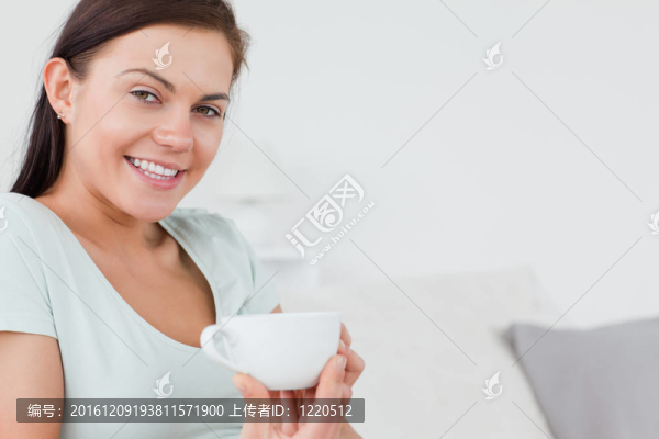 靠近一個女人坐在一杯咖啡的沙發(fā)