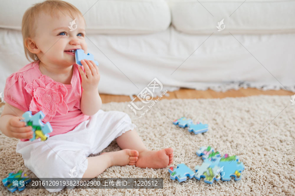 金發(fā)寶寶玩拼圖片坐在地毯上