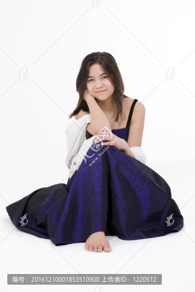 年輕的少女穿著深藍(lán)色的禮服在白色上孤立