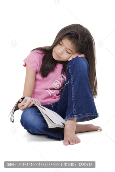 坐在地板上的小女孩在看雜志