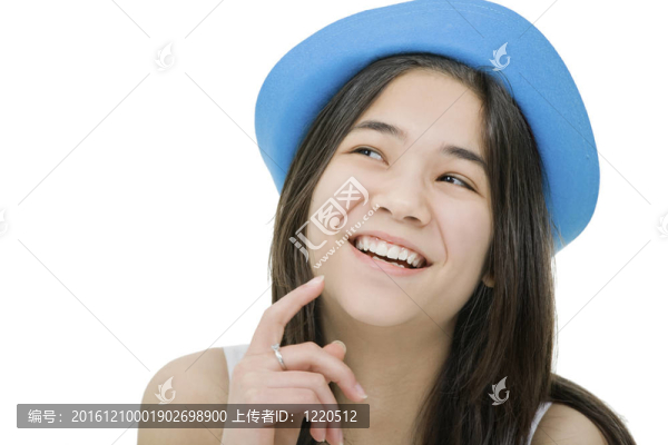 漂亮的戴著藍(lán)色帽子的年輕少女；用沉思的表情抬頭；仿佛她有一個(gè)有趣的想法或想法。白色隔離