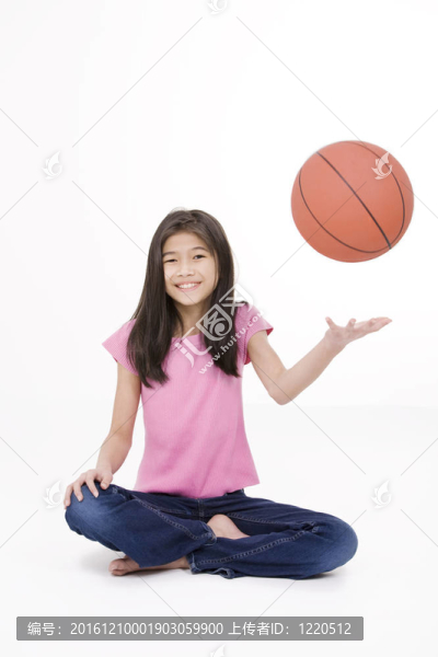 十歲的亞洲女孩舉行籃球；孤立的白色